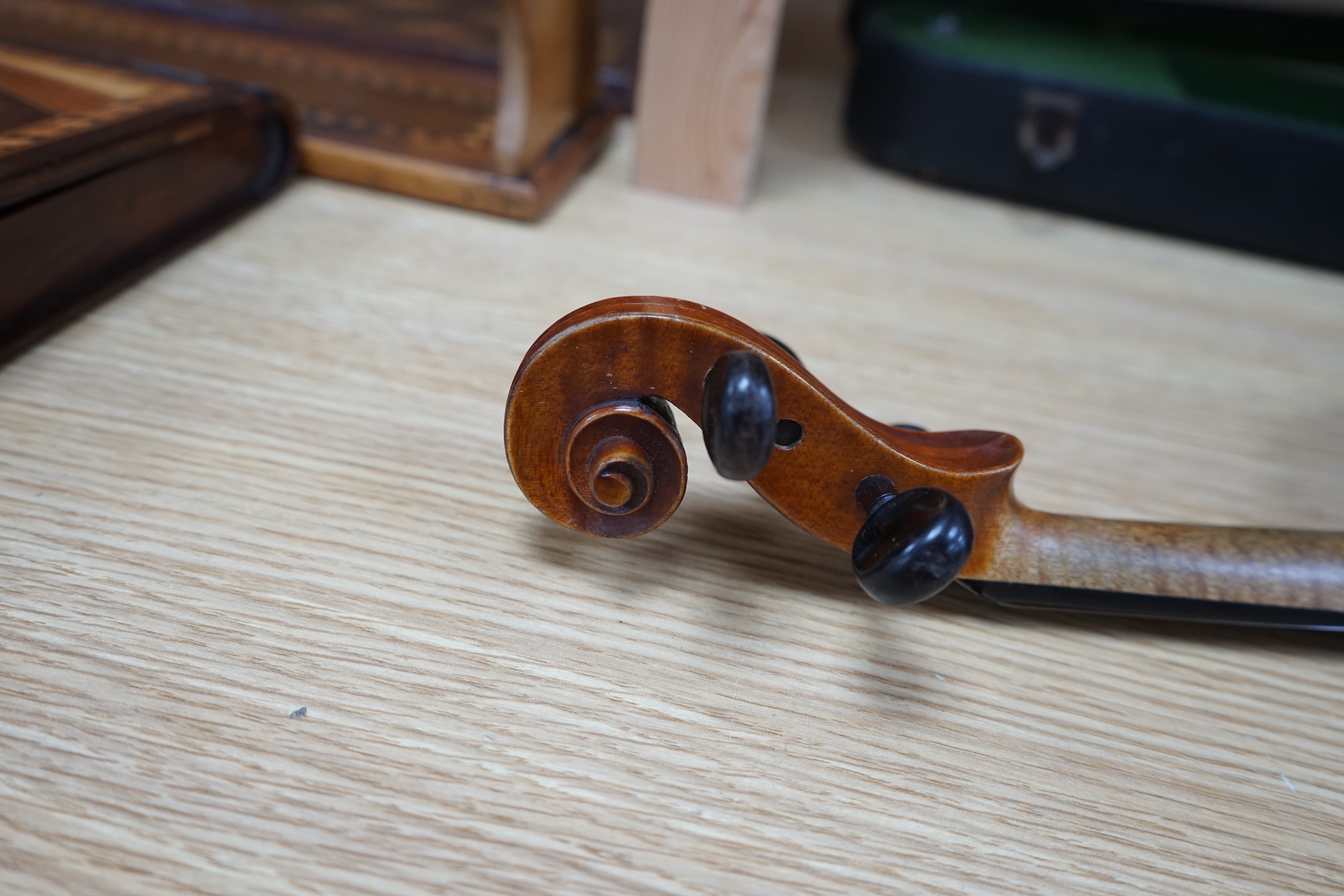 A cased early 20th century violin with bow, no label, back measures 35.5cm. Condition - fair to good